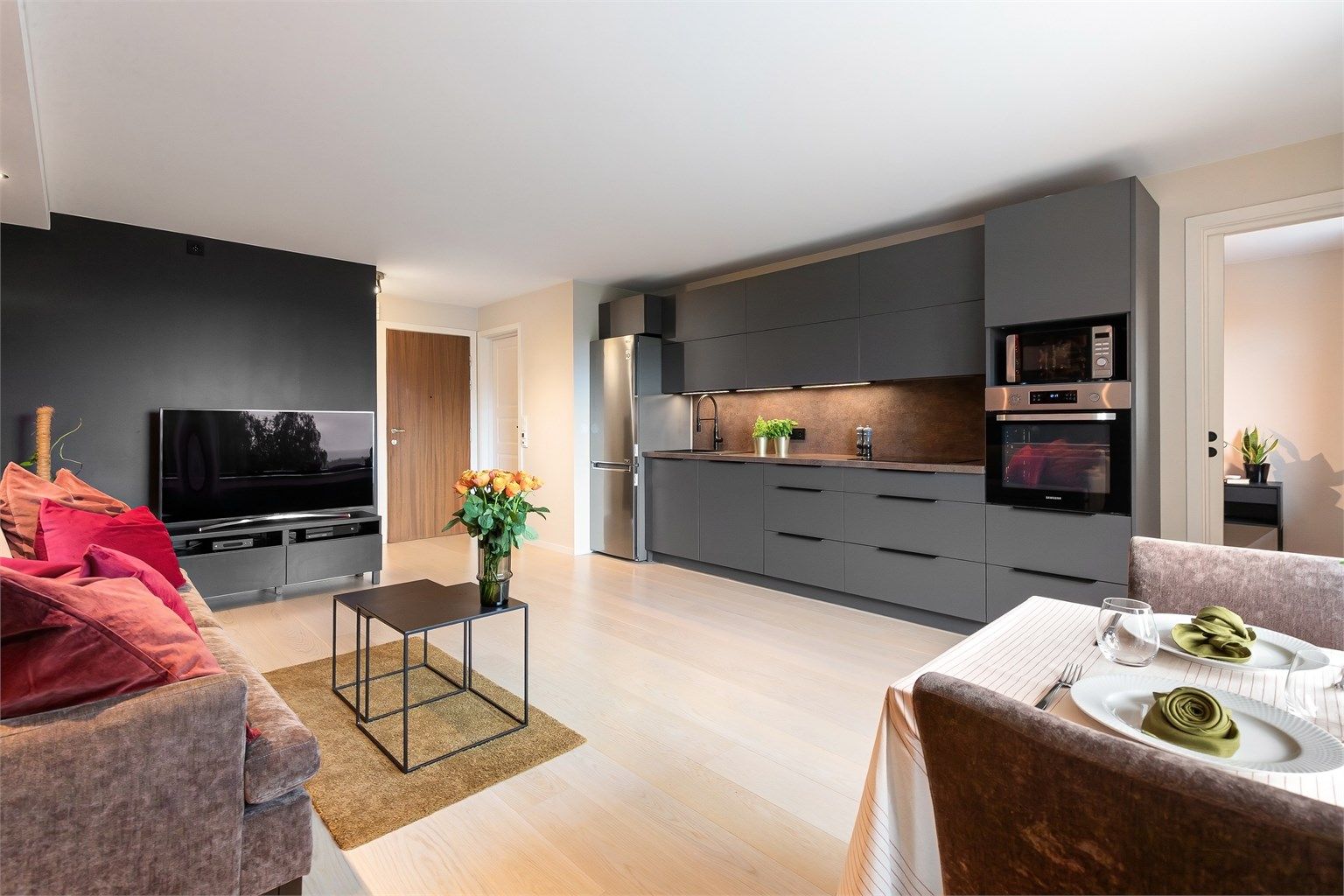 Rommet har plass for sofa, TV-seksjon og spisebord