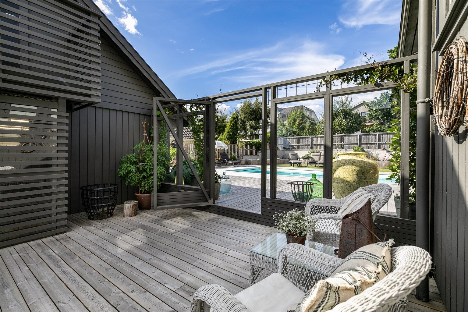 Inngangspartiets terrasse er i plan med bassengområdet innenfor.