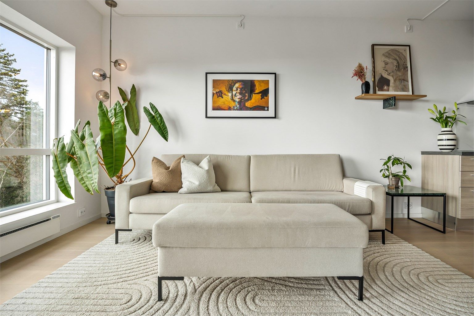 Åpen kjøkken- og stueløsning med sofaområde samt spiseplass.