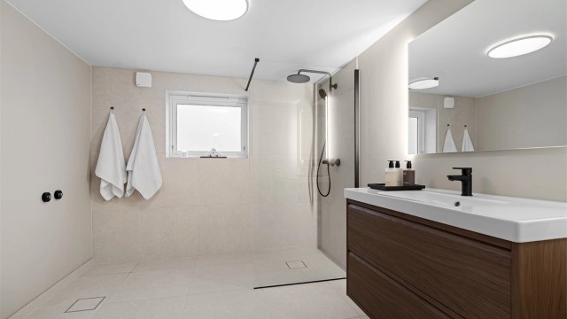 Godt belyst bad med speil med sidelys, klargjort til badekar