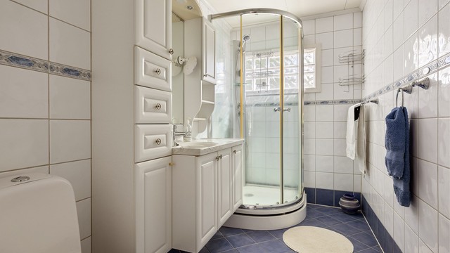 Badet i første etasje har flislagt gulv med gulvvarme og dusjkabinett.