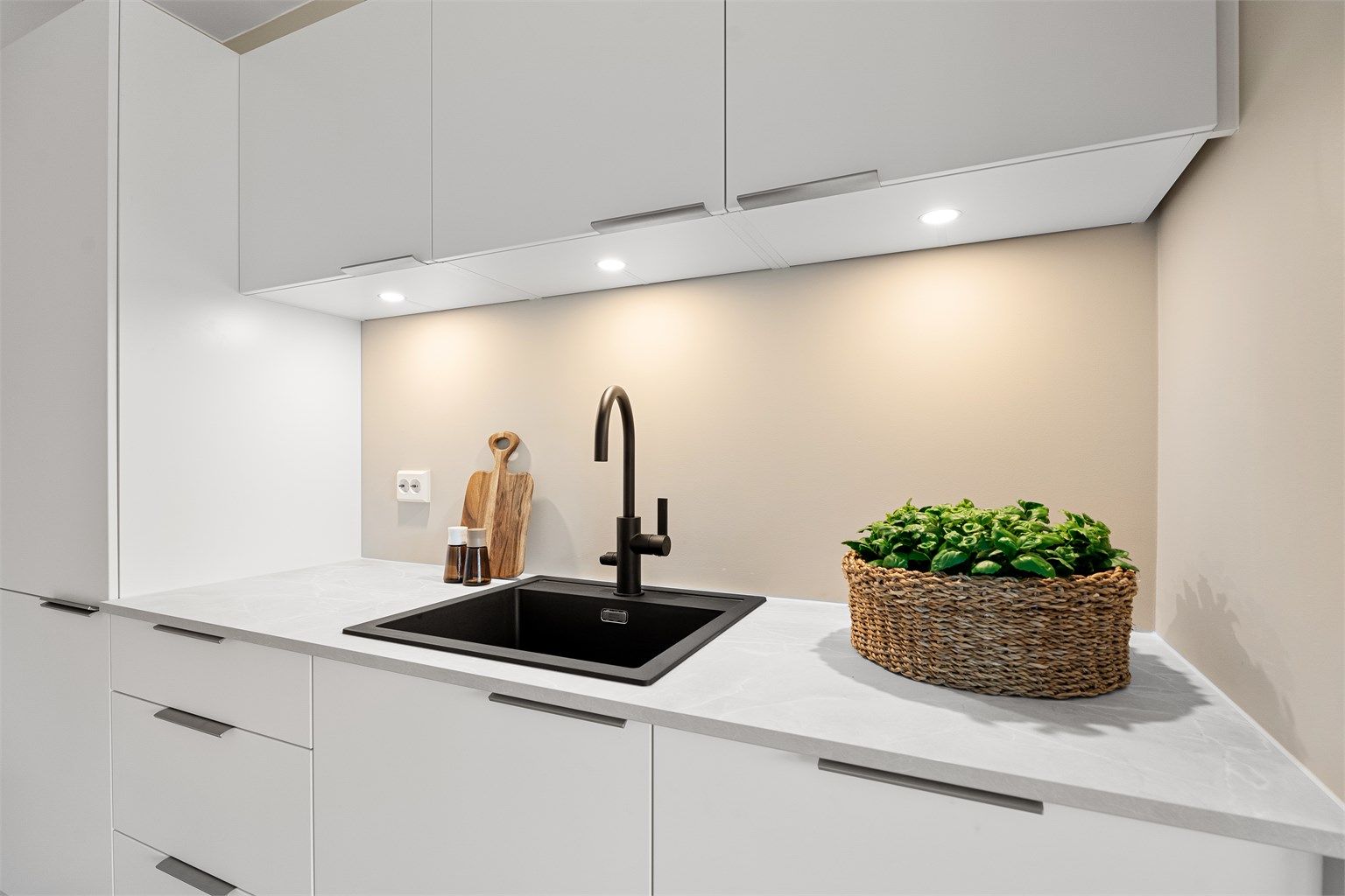 Det er downlights under overskapene samt en flott vask i svart utførelse. 