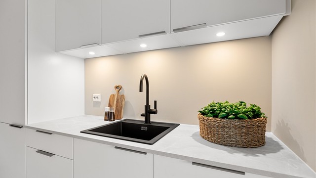 Det er downlights under overskapene samt en flott vask i svart utførelse.