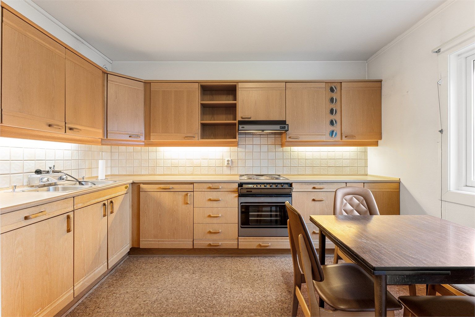 Kjøkkeninnredning med glatte fronter og benkeplate med laminert overflate.