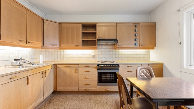 Kjøkkeninnredning med glatte fronter og benkeplate med laminert overflate.