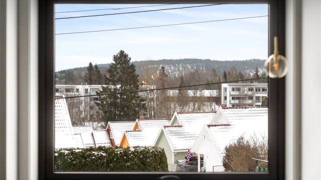 Fra stuevinduet er det utsikt over etablert eneboligbebyggelse med Østmarka i bakgrunnen.