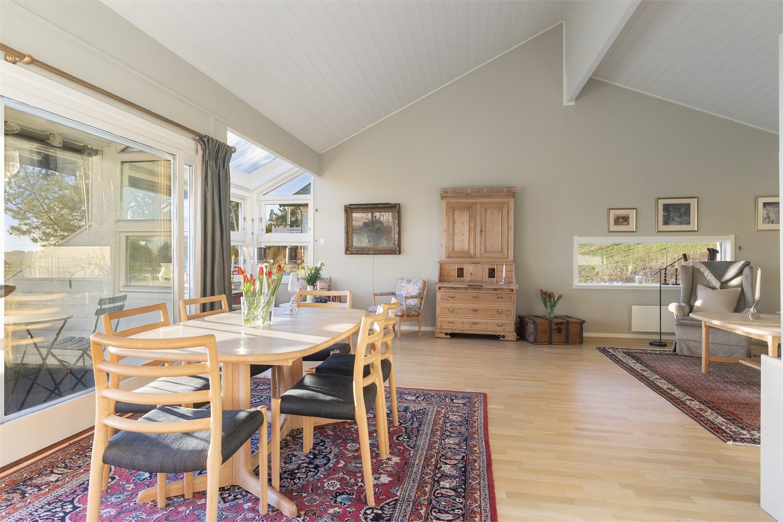 Oppholdsrommet har parkettgulv, malte vegger og panel i himling.