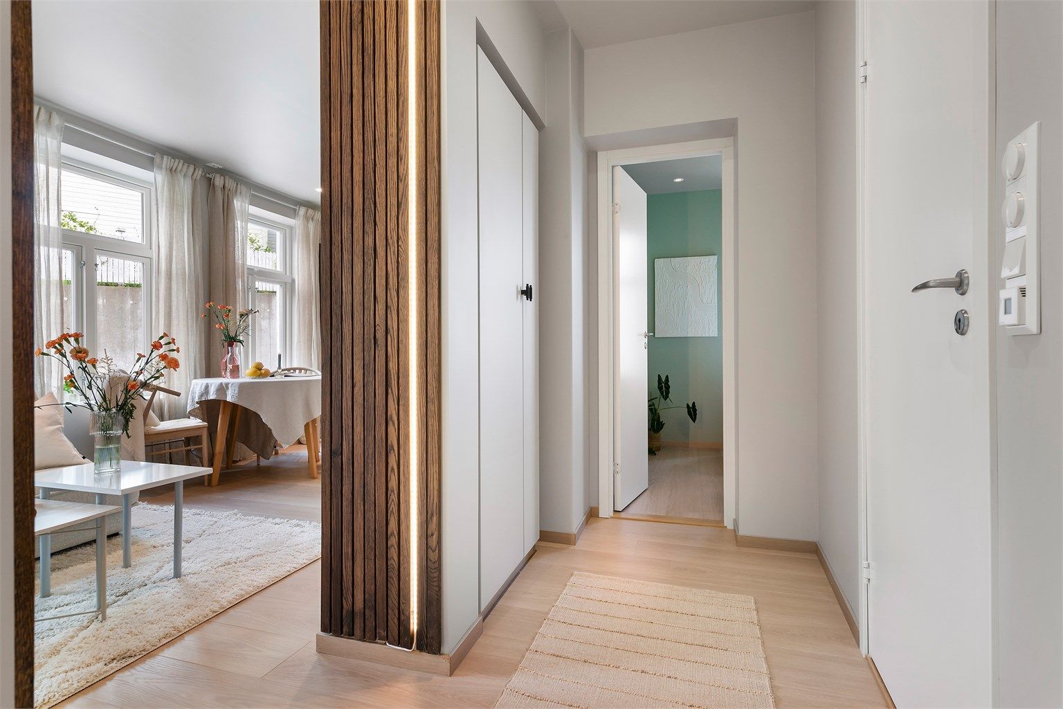 Velkommen inn! Entréen er åpen og luftig, med garderobeskap for yttertøy