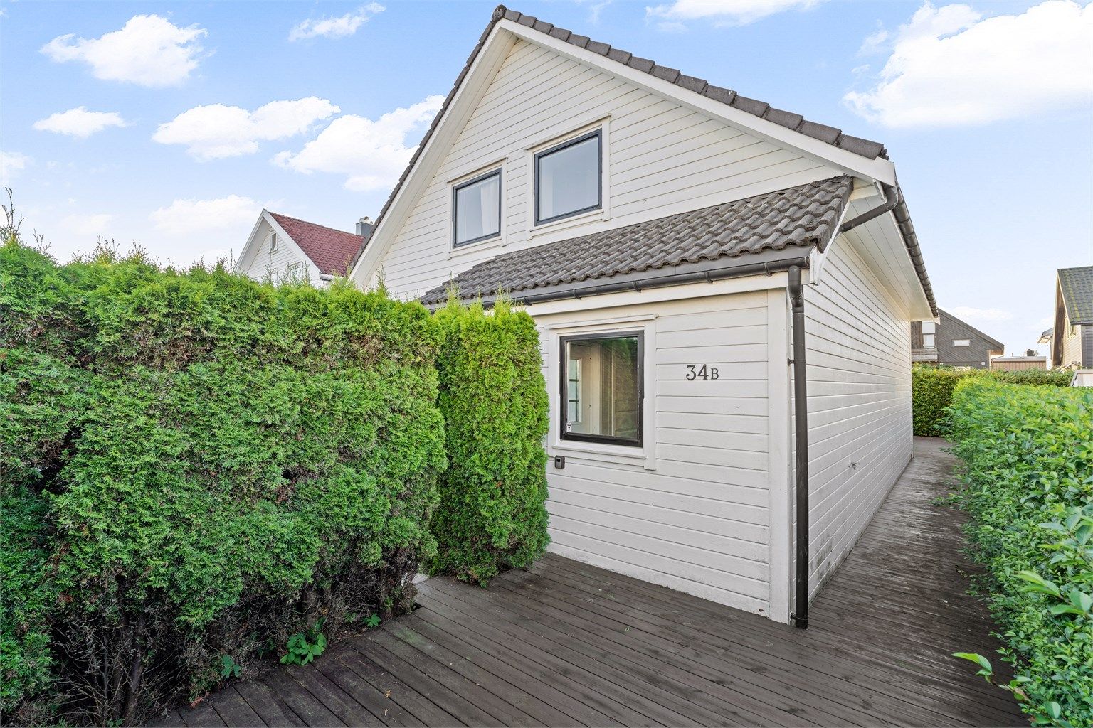 Platting omkranset av hekk langs boligen.