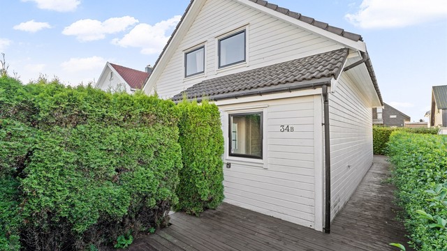 Platting omkranset av hekk langs boligen.