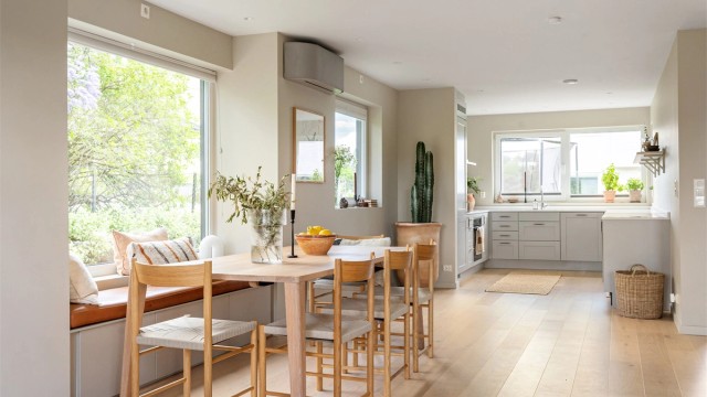 Spiseplassen er plassert ved et stort vindu som gir en lys og luftig atmosfære.
