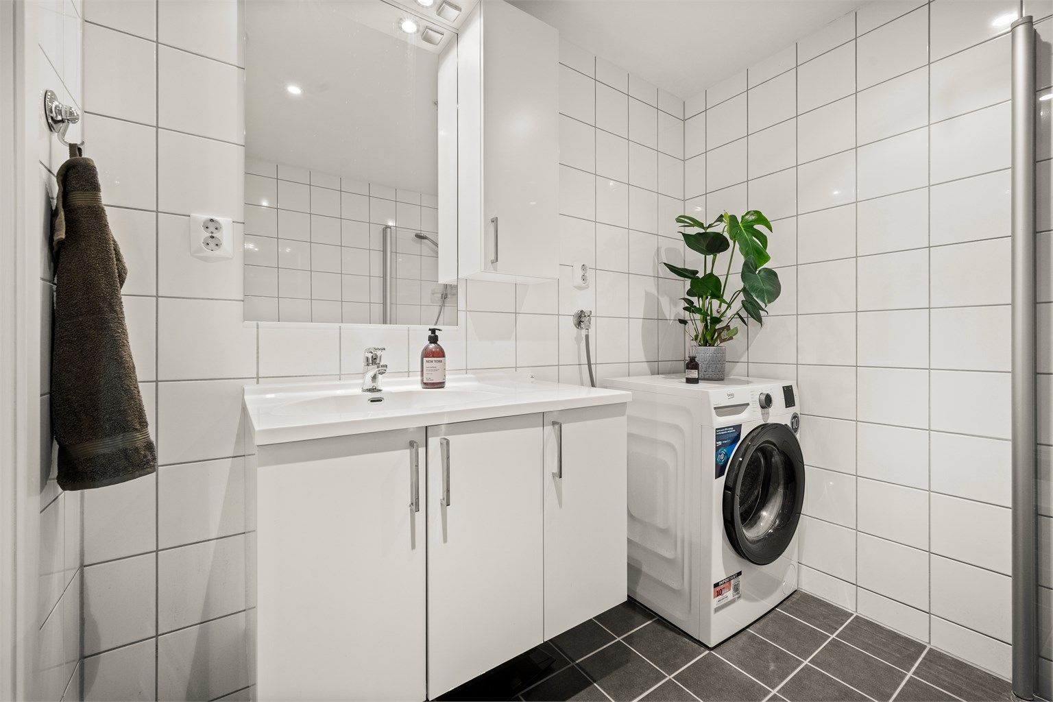 På badet er det opplegg for vaskemaskin og god oppbevaringsplass i servantskap og overskap.