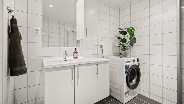 På badet er det opplegg for vaskemaskin og god oppbevaringsplass i servantskap og overskap.