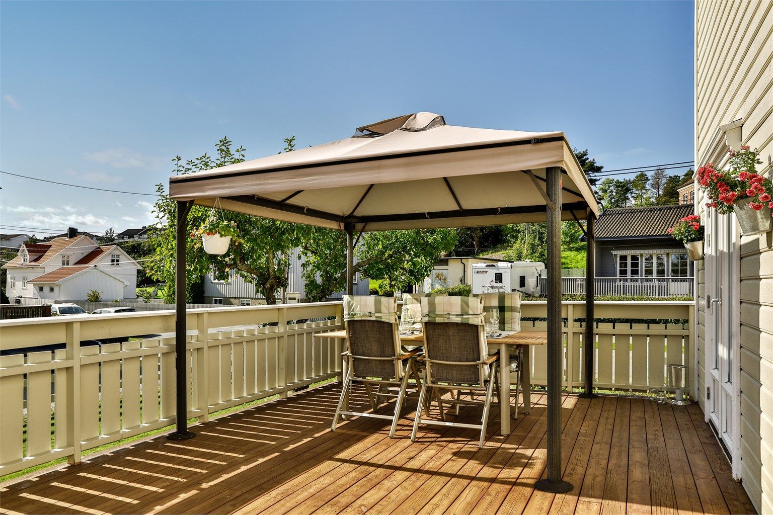 Ny terrasse ble oppført foran boligens sydside i 2006. Paviljongen medfølger. Bildet er tatt i 2019 og viser eiendommen sommerstid.