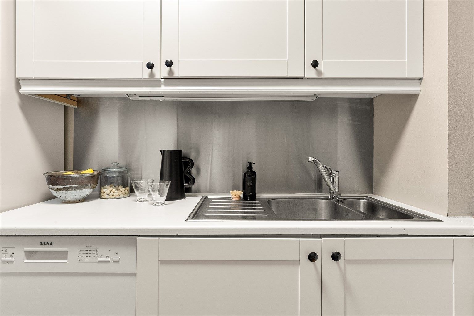 Plate i børstet stål over benkeplate.