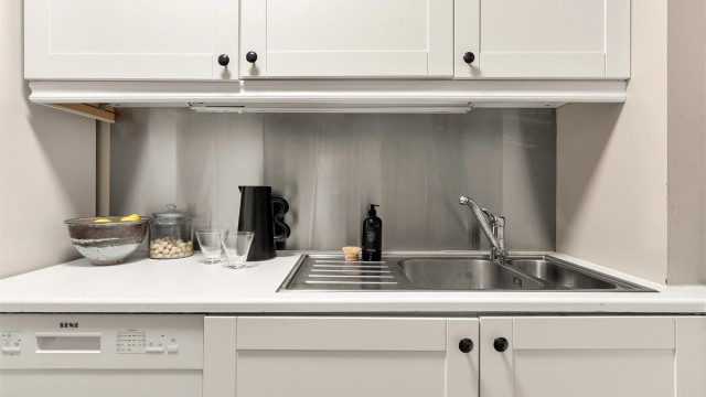 Plate i børstet stål over benkeplate.