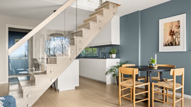 Den innvendige trappen i tre og glass er et sentralt designelement som binder de to etasjene elegant sammen.