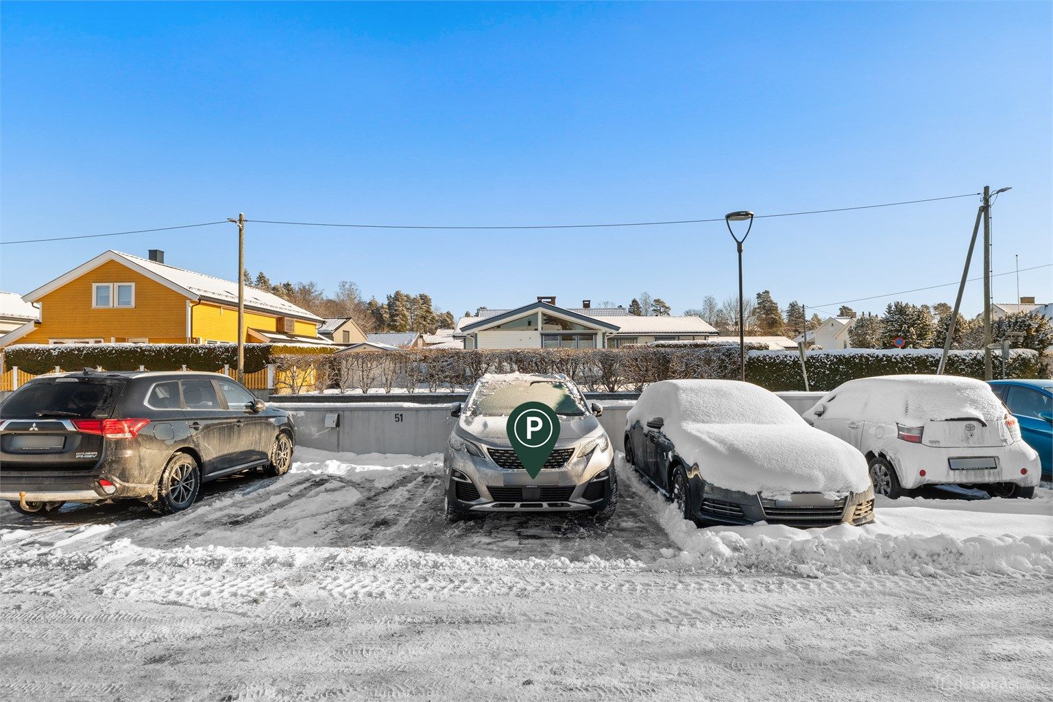 Det medfølger en parkeringsplass (nr. 50 ifølge selger) på taket av garasjeanlegget. Det er montert elbillader på plassen.
Oppmerkede gjesteparkeringsplasser på taket