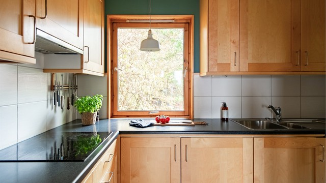 Nedfelt oppvaskkum og arbeidsbenk plassert under vinduet med koselig utsyn til hagen.