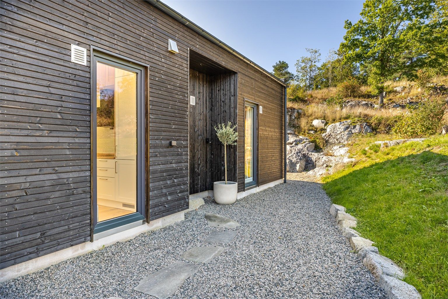 Hytta er omgitt av naturtomt og gruslagte stier.