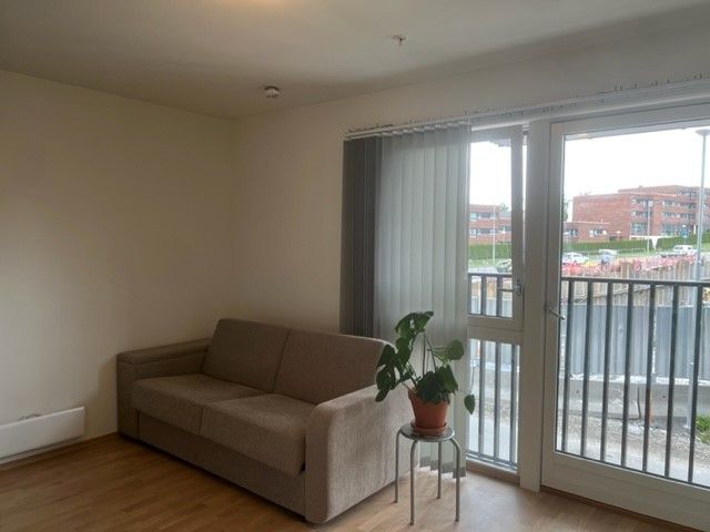 Stor vindusflate med utgang til fransk balkong. Lamellgardiner på vinduet for solskjerming.