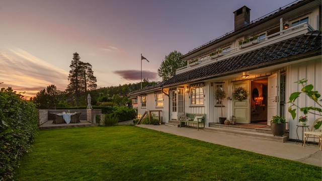 Eiendommen har flere uteplasser og en stor, flat gressplen.