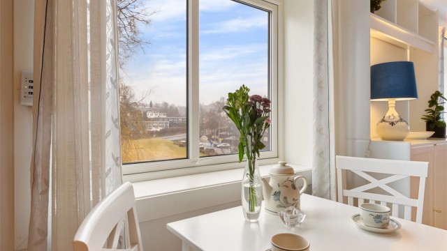 Ved kjøkkenvinduet er det en hyggelig plass for en liten spisegruppe.