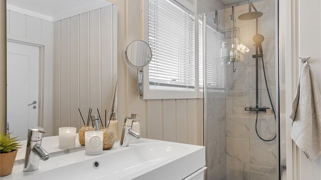 Badet har en dusjnisje med dusjvegg av glass og veggmontert regnfallsdusj