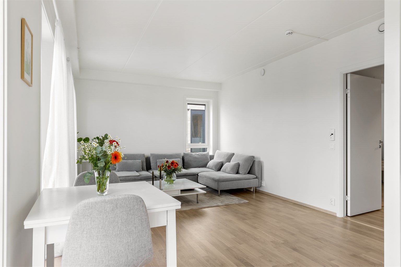 Leilighetens stue er lys og romslig med god plass til ønsket møblering.