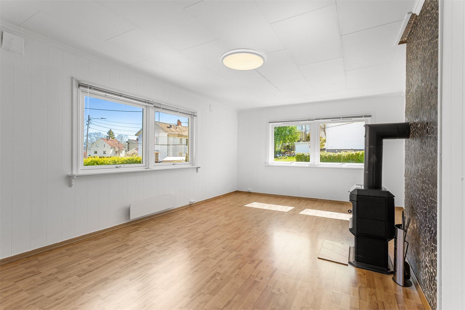 Stuen i første etasje er et lunt samlingspunkt med en vedovn for ekstra varme og hygge.