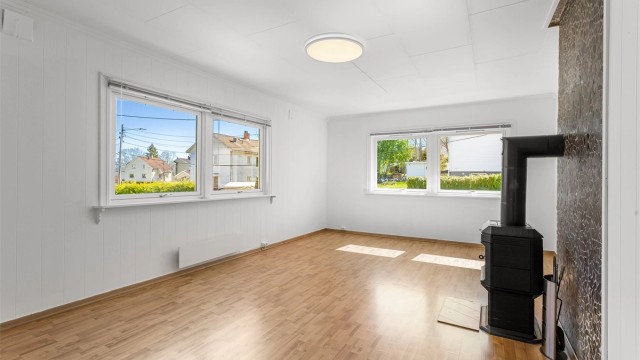 Stuen i første etasje er et lunt samlingspunkt med en vedovn for ekstra varme og hygge.