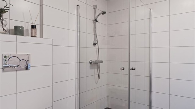 Badet er utstyrt med et praktisk dusjhjørne med innfellbare dører og vegghengt toalett.