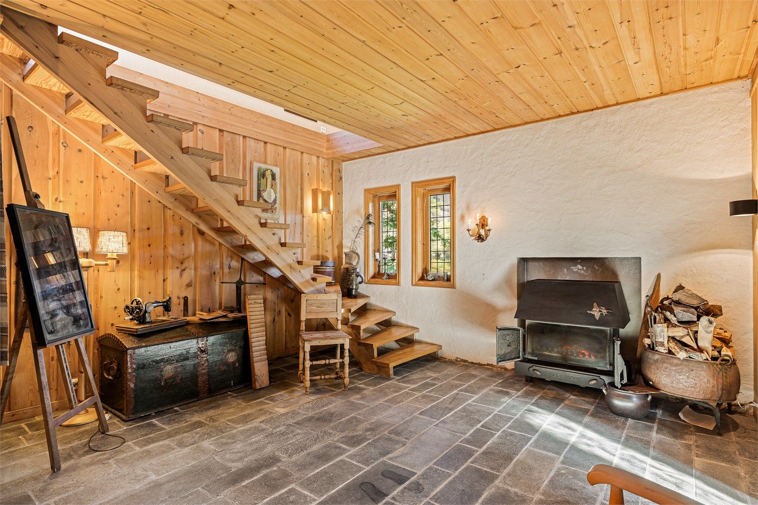 Fra vindfanget kommer du inn en romslig hall som også brukes som kjellerstue. Den solide peisen er fint plassert i en nisje.