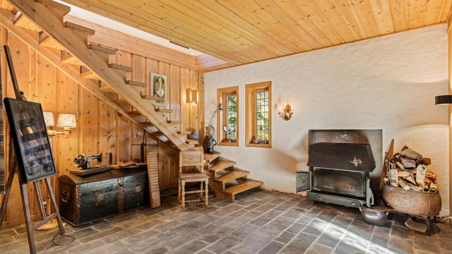 Fra vindfanget kommer du inn en romslig hall som også brukes som kjellerstue. Den solide peisen er fint plassert i en nisje.