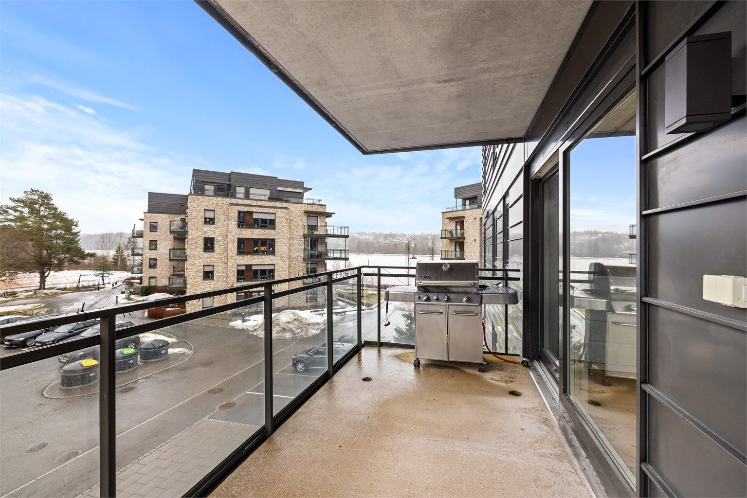 Balkongen har en solid betongkonstruksjon med et moderne rekkverk i metall og glass.