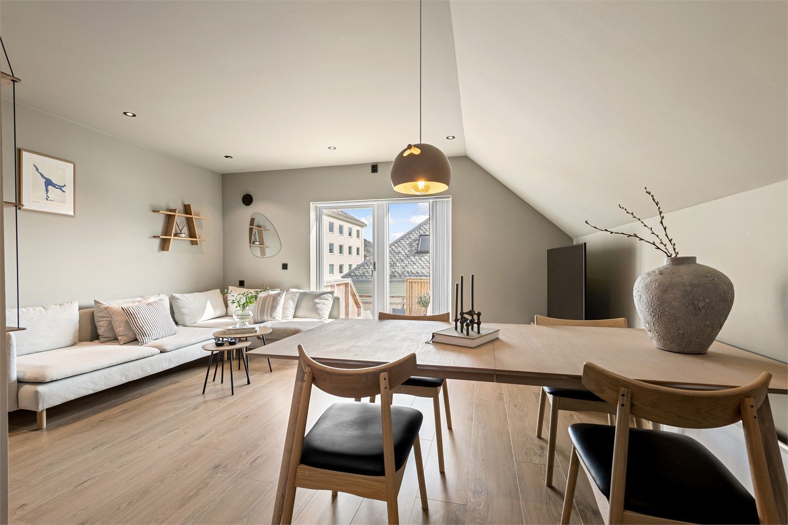 Stue med god plass til både sofagruppe og spisebord i tilknytning til kjøkken