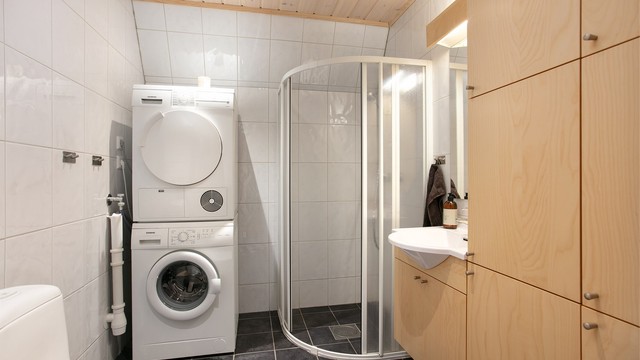 Bad med flislagt gulv, elektriske varmekabler og opplegg for vaskemaskin.