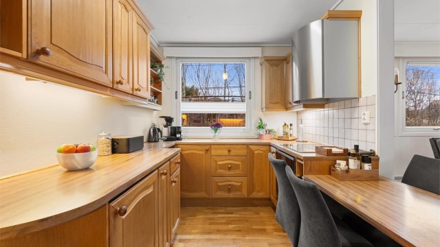 God arbeidsflate på benkeplater av tre og laminat, med belysning under overskapene.