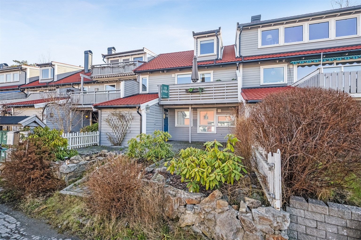 Disp. tomt er pent opparbeidet med belegningsstein, div. beplantninger, overbygget platting ved inngangsparti samt stor usjenert terrasse/hage og balkong.  