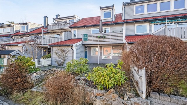 Disp. tomt er pent opparbeidet med belegningsstein, div. beplantninger, overbygget platting ved inngangsparti samt stor usjenert terrasse/hage og balkong.