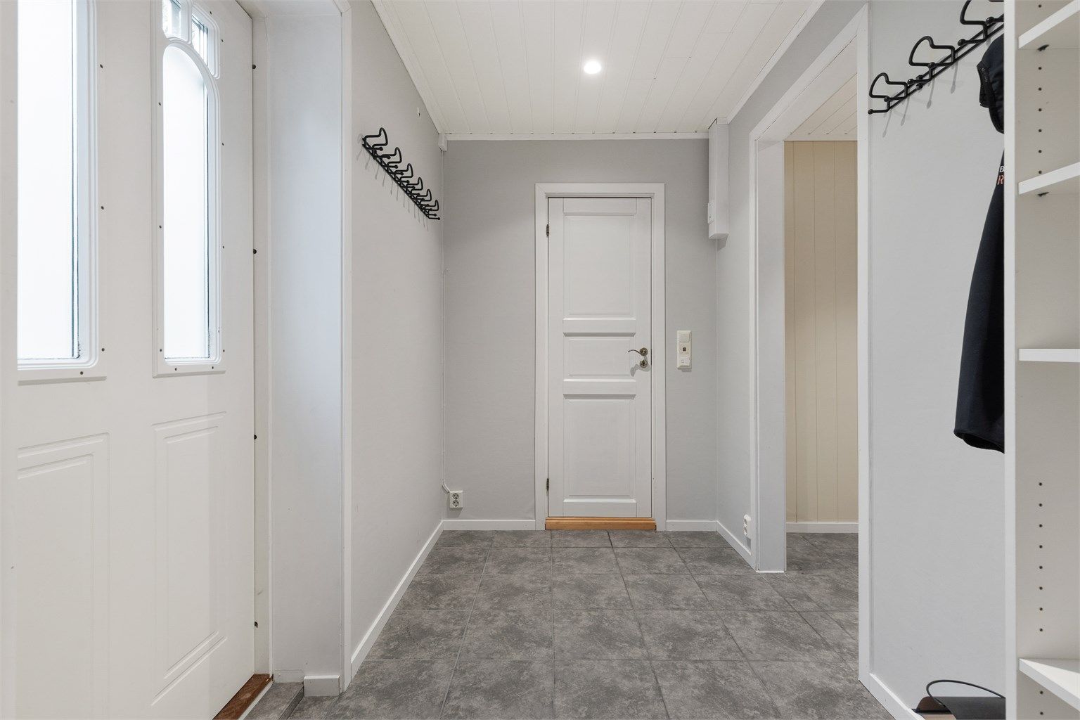 Inngangsparti til underetasje med inngangsdør på nordsiden av huset.