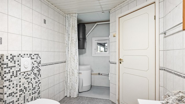 Badet har en praktisk nisje med opplegg for vaskemaskin og plass til varmtvannsbereder.