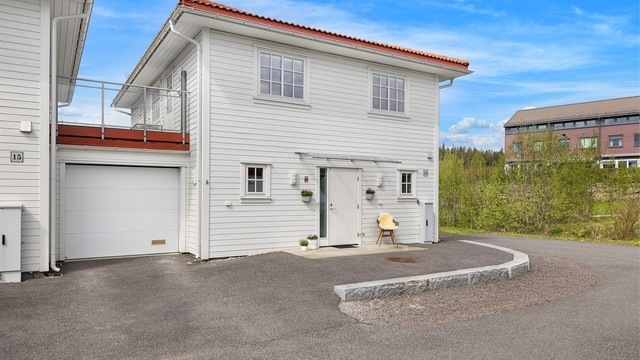 Boligen har et pent inngangsparti med overbygg og utebelysning.
