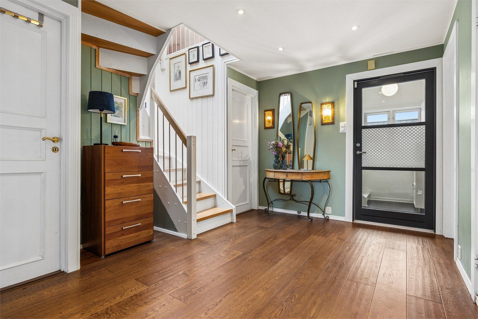 Romslig entré med god plass til garderobeløsninger. Ytterdøren i tre med glassfelt er fra 2020.