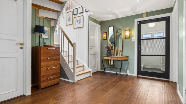 Romslig entré med god plass til garderobeløsninger. Ytterdøren i tre med glassfelt er fra 2020.