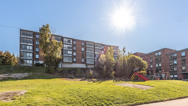 Boligblokken ligger omkranset av fine, grønne fellesarealer.