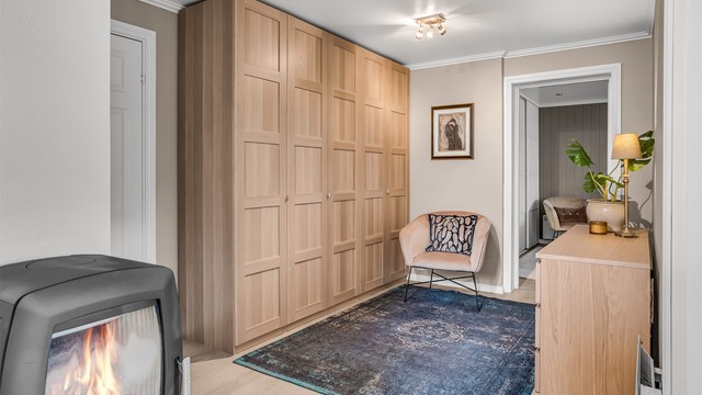 Gangen i underetasjen er utstyrt med peisovn og romslig garderobe.