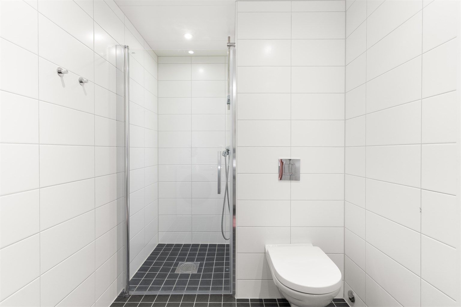 Badet er videre innredet med dusj, vegghengt toalett og elektriske varmekabler. 