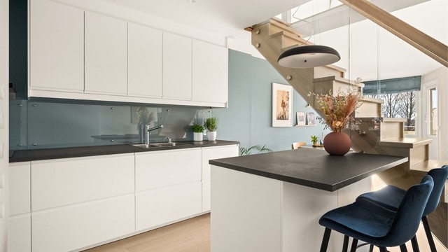 Trappen med glassrekkverk bidrar til å bevare åpenheten og lyset mellom rommene.