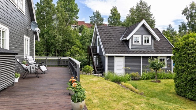 Fra terrassen er det adkomst til en pent beplantet hage med gressplen.